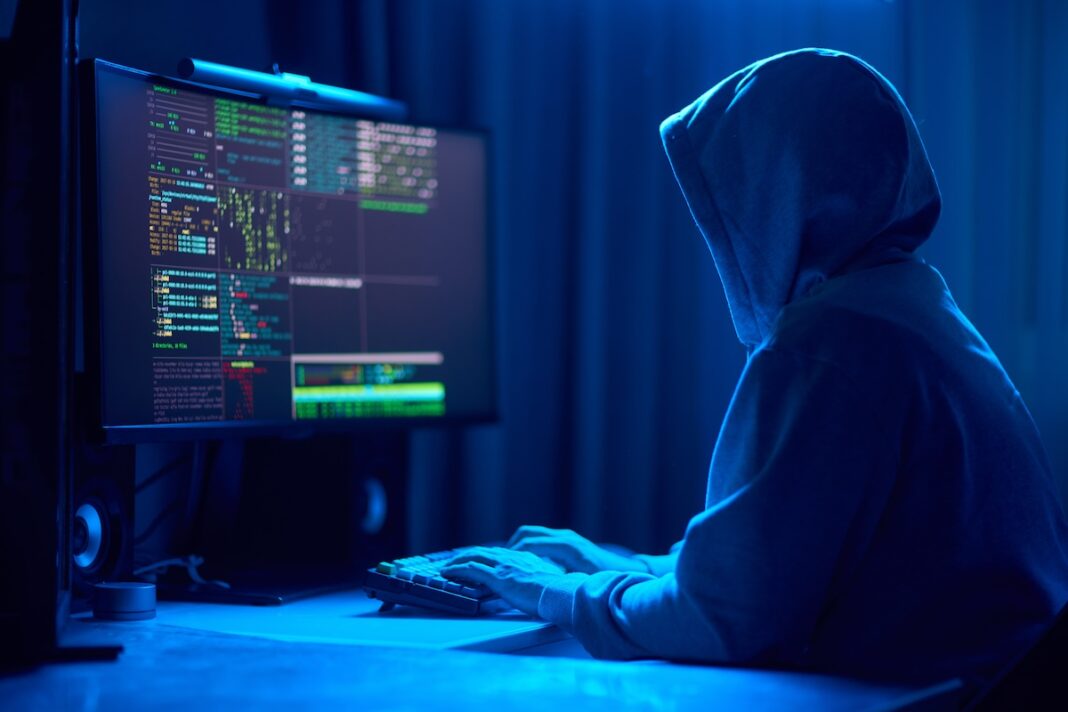 10 2 Dimly Lit Room Cloaked Figure Types Code Computer Hinting Mysterious Hacker